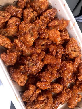 Kızarmış Kore tavuğu, tatlı ve baharatlı sosla mükemmel bir şekilde jölelenmiş. Yemek fotoğrafçılığı ve menüler için idealdir. Bu sevilen yemeğin dayanılmaz çıtırtısını ve lezzetini sergiler..