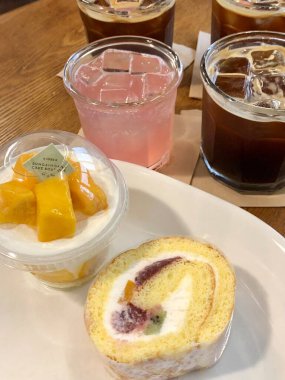 Hoş bir kafe ortamında sergilenen tatlı çeşitleri zarif tabaklar üzerinde pastalar, pastalar ve tatlı ikramlar, sıcak ve davetkar bir atmosfer yaratıyor..