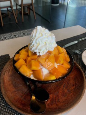 Tüylü buzlu mango bingsu, tatlı mango parçaları ve yoğun sütlü krema. Sıcak günler için mükemmel bir Kore tatlısı, lezzetli meyveli ve kremalı tatlar dengesi sunuyor.!