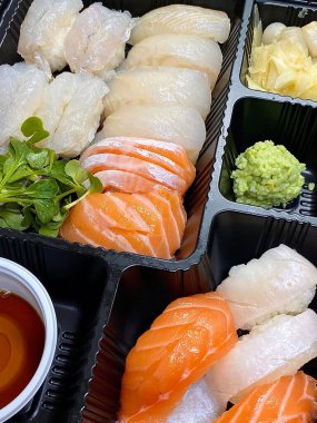 Çeşitli malzemeler ve canlı renklerle sanatsal olarak düzenlenmiş taze suşi çeşitleri. Bu geleneksel Japon yemeği bir deneyim için sirkeli pirinç, deniz ürünleri ve sebzeleri birleştirir..