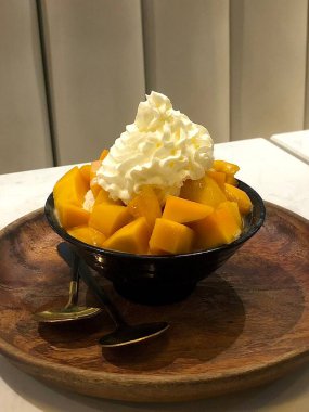 Tüylü buzlu mango bingsu, tatlı mango parçaları ve yoğun sütlü krema. Sıcak günler için mükemmel bir Kore tatlısı, lezzetli meyveli ve kremalı tatlar dengesi sunuyor.!