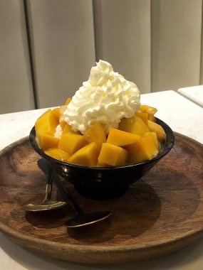 Tüylü buzlu mango bingsu, tatlı mango parçaları ve yoğun sütlü krema. Sıcak günler için mükemmel bir Kore tatlısı, lezzetli meyveli ve kremalı tatlar dengesi sunuyor.!