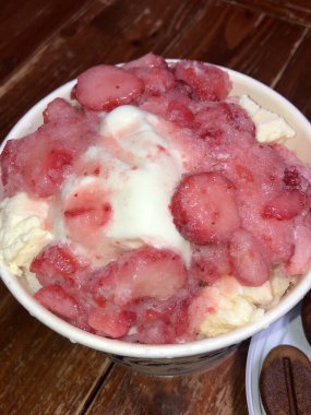 Refreshing bingsu, a Korean shaved ice dessert topped with sweet ingredients like red beans, fruits, and condensed milk. A perfect treat to cool down on hot days.
