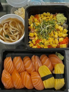 Fresh assorted sushi paired with warm, savory udon noodles in rich broth, offering a perfect combination of delicate flavors and comforting warmth in every satisfying, well-balanced bite.