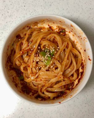 Baharatlı ve keskin bibim guksu, çiğnenmiş erişteler, taze sebzeler ve gochujang sosu. Canlı ve ferahlatıcı bir Kore soğuk erişte tabağı hafif ama lezzetli bir yemek için mükemmel..