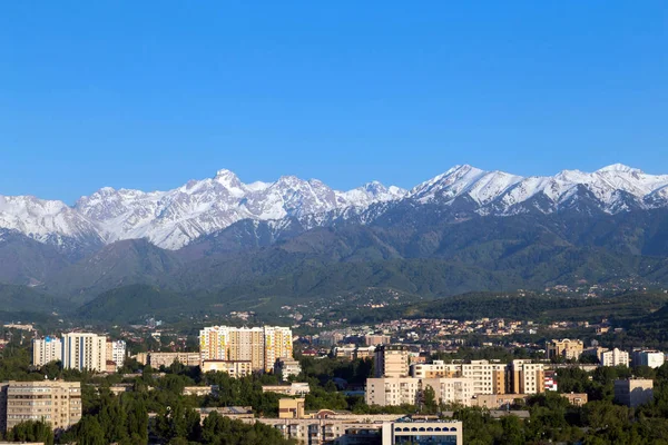 Dağların üzerinden Almatı şehir öğleden sonra. Bahar kentsel peyzaj.