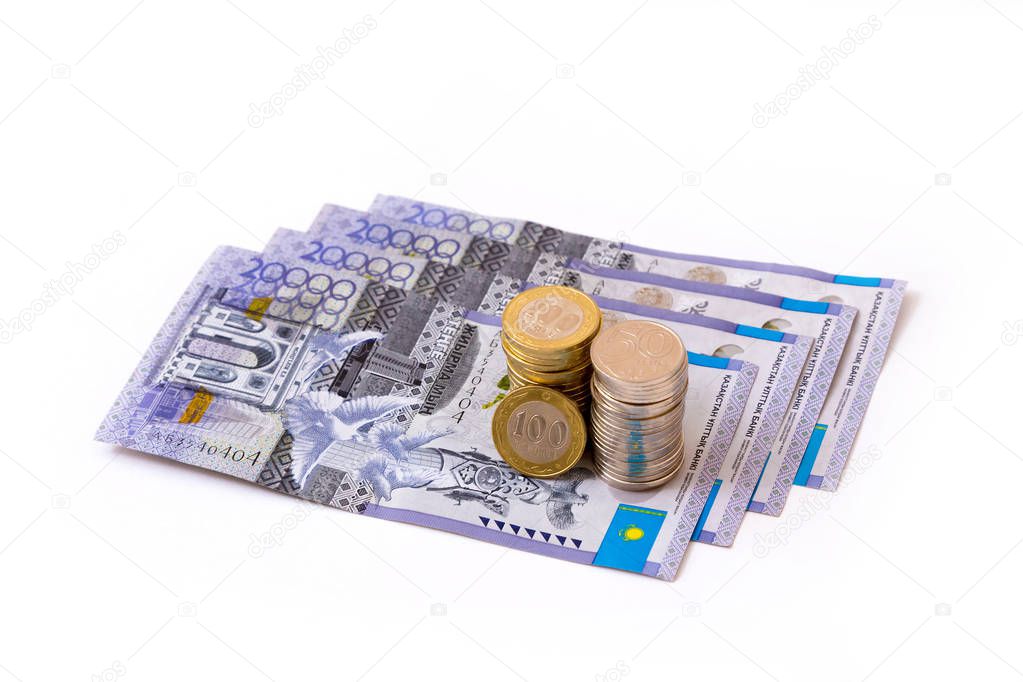 Closeup of a collection of kazakhstani tenge banknotes and coins isolated on white background