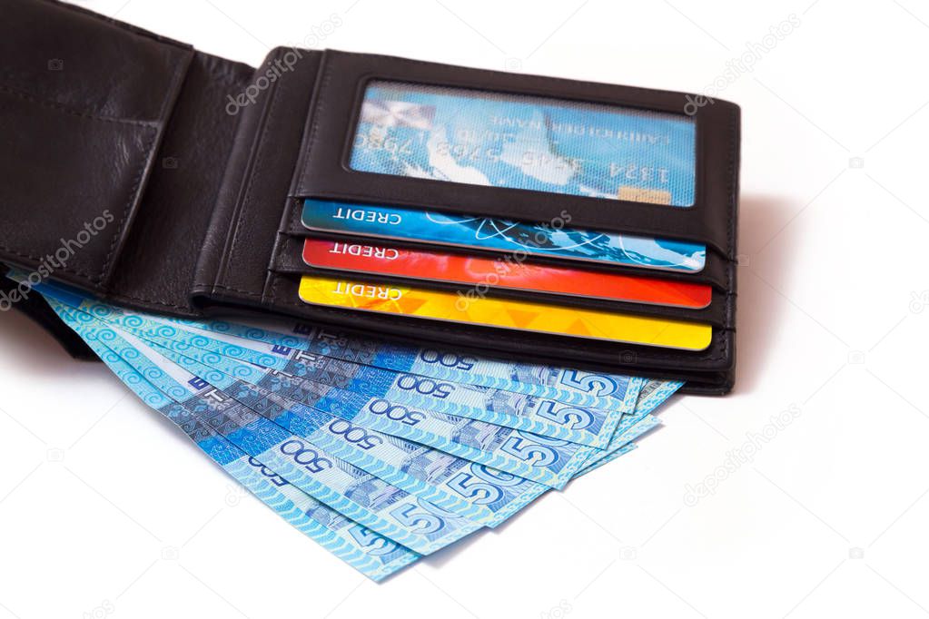 Closeup of a black leather wallet with colourful credit cards and kazakhstani tenge banknotes in it, isolated on white background