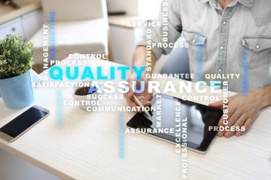 Kalite güvencesi kavramı sanal ekran üzerinde. İş kavramı. Kelime bulutu.