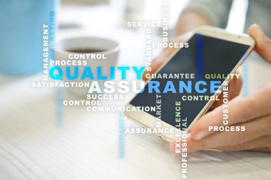 Kalite güvencesi kavramı sanal ekran üzerinde. İş kavramı. Kelime bulutu.