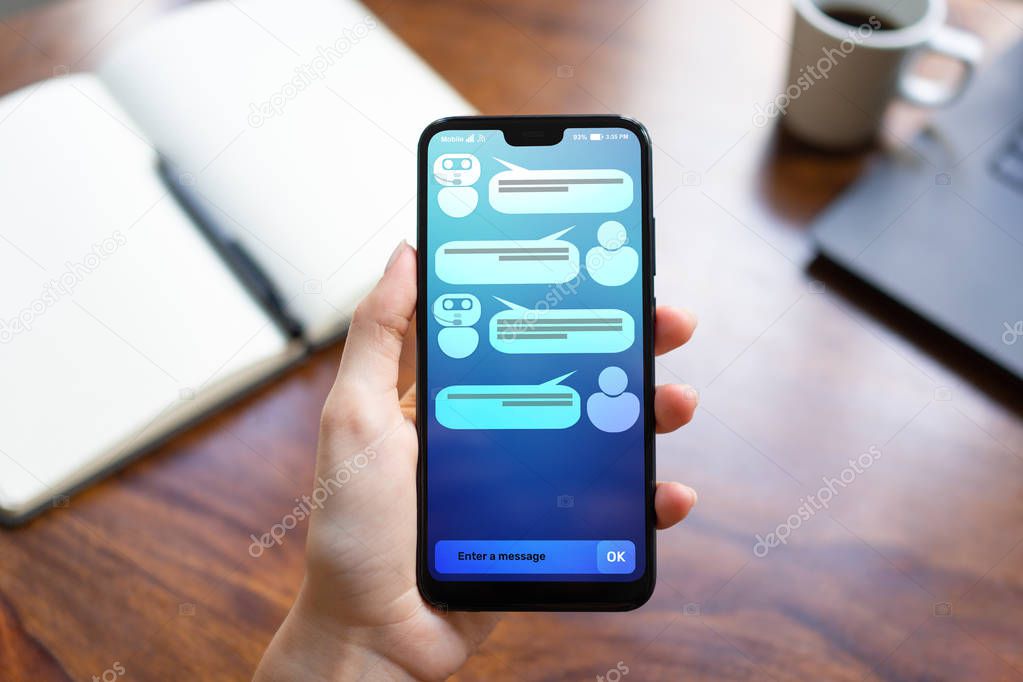 Customer and chatbot dialog on smartphone screen. AI. Artificial intelligence and service automation technology concept.