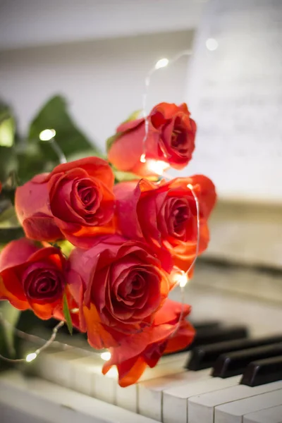 Κόκκινα Τριαντάφυλλα Ένα Λευκό Πιάνο Νότες Και Γιρλάντες — Φωτογραφία Αρχείου