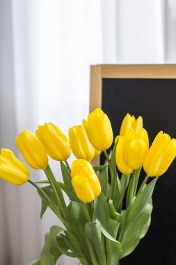 Bir tahta arka plan üzerinde sarı lale bir buket