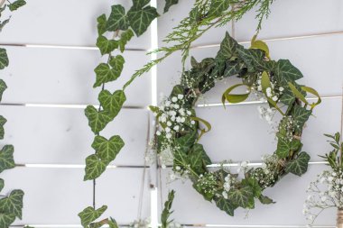 Bahar dekoru. Paskalya dekoru. Photozone. Ahşap beyaz bir arka plan üzerinde yaprakların bir çelenk. 