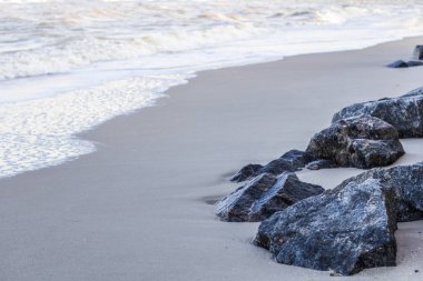 Kumlu sahildeki taşlar. Deniz dalgaları