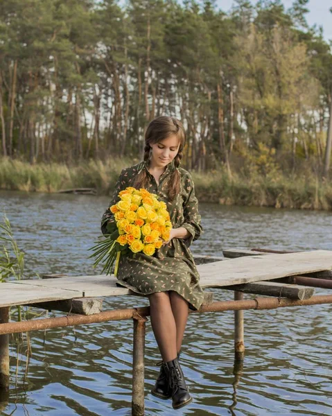 Bir buket sarı gülü olan güzel bir kız. Nehir kenarındaki etkili kadın. Özel bir kadın. Sarı güllü genç kız. Eski köprüdeki kız.