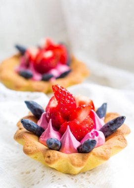 Çilek, hanımeli ve pembe kremayla kaplanmış lezzetli kekler.