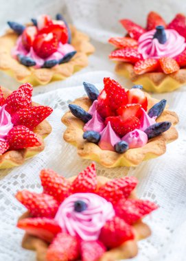 Çilek, hanımeli ve pembe kremayla kaplanmış lezzetli kekler.