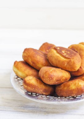 Piroshki - Rus usulü lahana dolgulu puf böreği. Geleneksel Rus lahanası doldurulmuş hamur işi. Lahanalı yağsız turtalar. Güzel ev yapımı kekler ve beyaz metal tabaklarda lahana. 