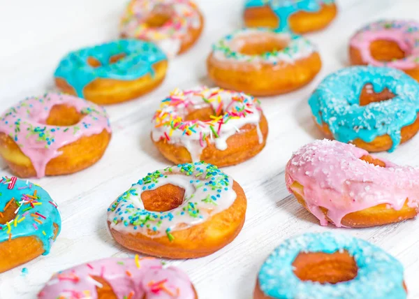 色彩艳丽的杜努兹蓝绿色和粉色图案 白种人背景 多色釉面的甜甜圈 甜甜圈是传统的甜糕点 一套五颜六色的甜甜圈 — 图库照片