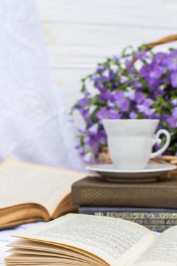 Fincanlı kahve (çay), kitaplar ve hasır sepette keten çiçekleri
