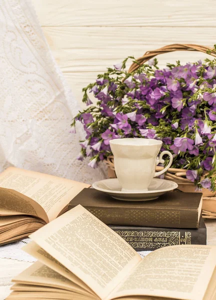cup coffee (tea), books and bouquet flax in wicker basket. Retro style, vintage