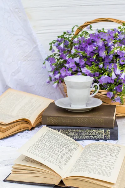 cup coffee (tea), books and bouquet flax in wicker basket