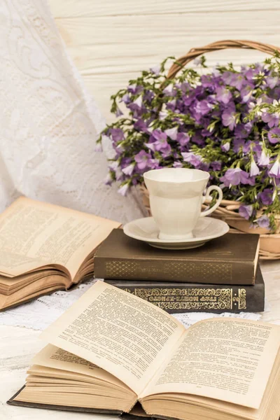 cup coffee (tea), books and bouquet flax in wicker basket. Retro style, vintage