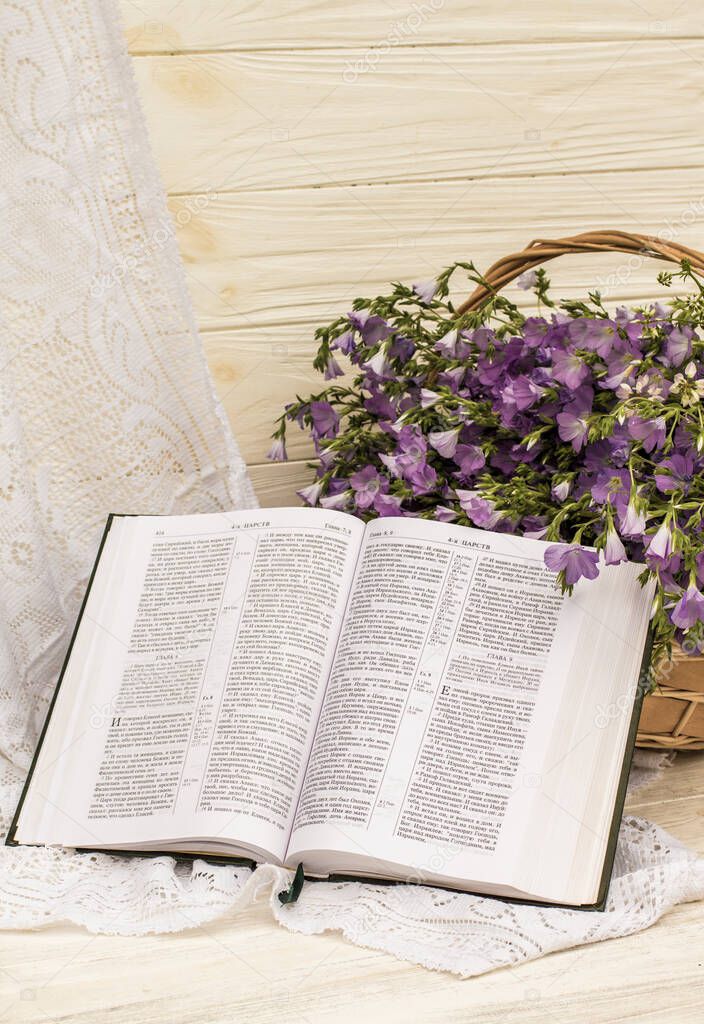 Open Bible and bouquet flax in wicker basket. Retro style, vintage