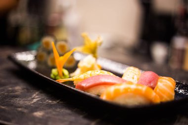 Suşi ve rulo arka plan, siyah, en iyi görünümü karede. Renkli Japon restoranı Mama seti, kopya alanı