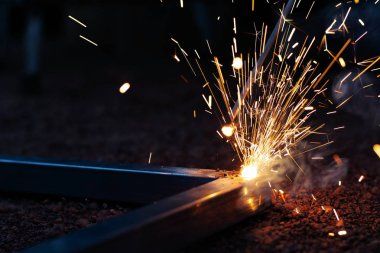 Teknisyen kaynak işlemi kıvılcım ekipman ile ışık üzerinde odak.