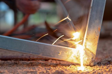 Teknisyen kaynak işlemi kıvılcım ekipman ile ışık üzerinde odak.