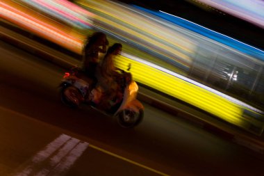 İki kişi bir motosiklet binmek. Uzun pozlama soyutlama.