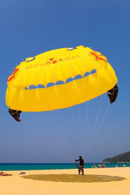 Karon, Tayland, 16 Şubat 2018: İçinde belgili tanımlık geçmiş - gökyüzü ve denizin bir paraşüt sarı bir kubbe altında bir paraşütçü.