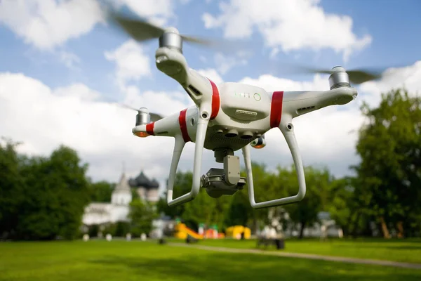 Bir dron bir kamera ile parkta yaz aylarında uçar. Mühendislik ve elektronik