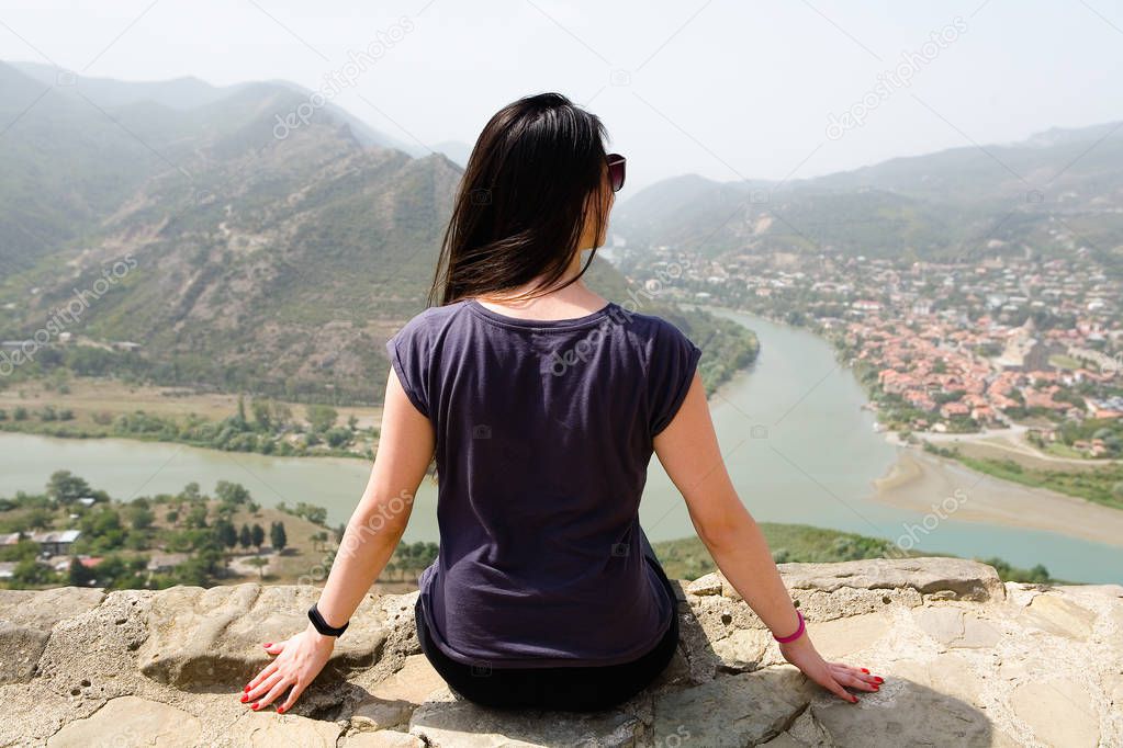 A girl in the background of the city of Mtskheta. Back to the camera.