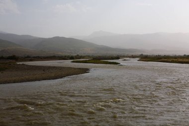 Nehir ve dağ kara sevdanın acele akışı. Manzara.