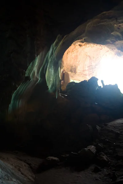De ingang van de grot is verlicht door het licht buiten — Stockfoto