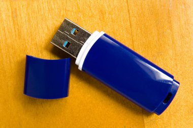 Mavi Usb sürücü bir ahşap yüzeye yatıyor.