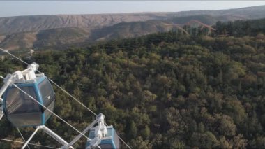 Tiflis 'te Mtatsminda parkta dönme dolabı görünümü. Havadan video çekimi.