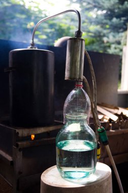 Kaçak içki, ev yapımı kaçak içki aparatından bardağa akar.