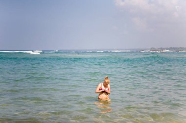 Mayolu bir kız okyanusta duruyor. Tatil köyünde dinlen..
