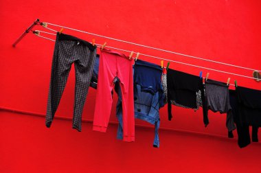 Çamaşırhane pencerenin kırmızı ev cephe zemin İtalya üzerine mandal, kullanarak bir tel üzerinde dışında kurutma.