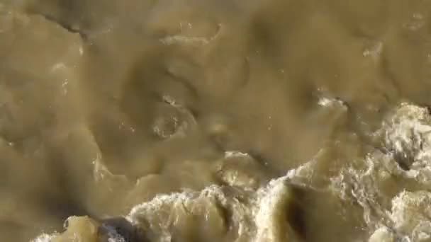 Des ruisseaux de rivière grise sale après une tempête 