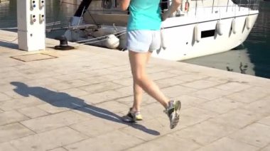 Hırvatistan. Makarska. Genç bir kız iskele ve deniz kıyı boyunca çalışır