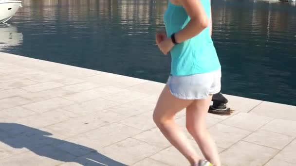 Croatie. Makarska. Une jeune fille court le long de la jetée le long de la mer — Video