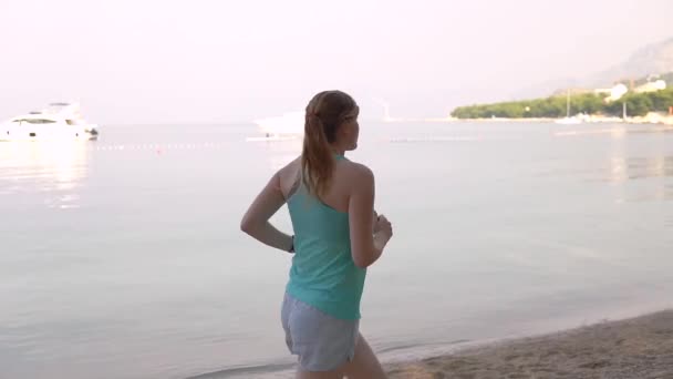 Junges Mädchen läuft am Strand in Zeitlupe — Stockvideo