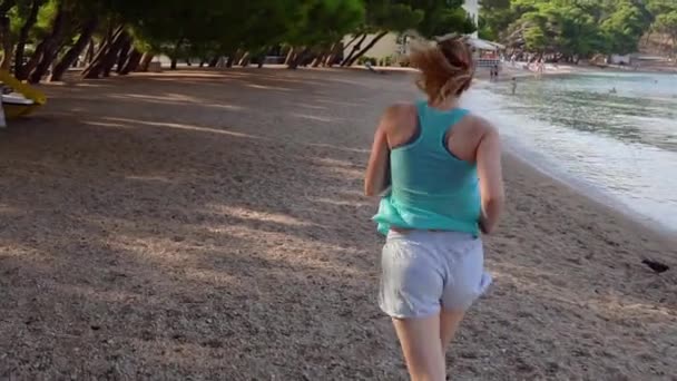 Giovane ragazza che corre sulla spiaggia al rallentatore — Video Stock