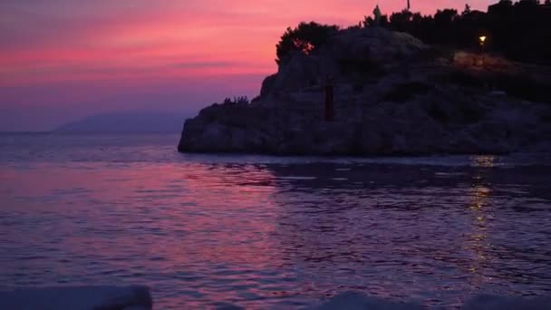 Croácia. Makarska. Pôr do sol sobre o mar e vista do farol — Vídeo de Stock