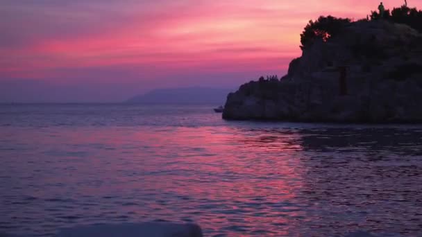 Croácia. Makarska. Pôr do sol sobre o mar e vista do farol — Vídeo de Stock